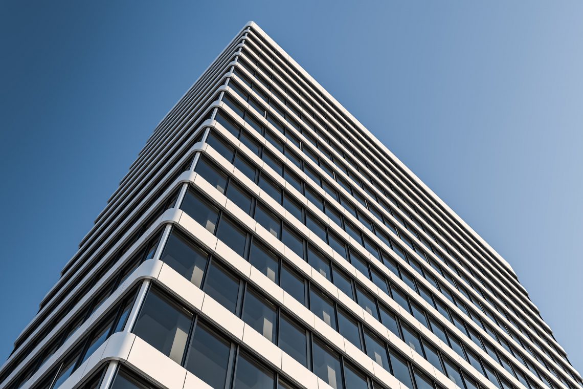 Blick von unten hinauf auf das Hochhaus H1 vor blauem Himmel